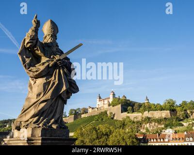 Scultura, San Kilian, statua di San Kilian sul vecchio ponte principale, dietro la Fortezza di Marienberg, Würzburg, bassa Franconia, Baviera, Germania, Europa Foto Stock