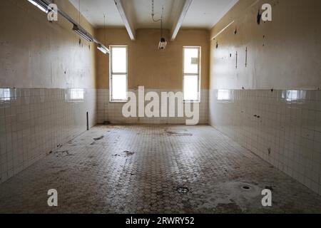 Vecchia stanza piastrellata in una vecchia fabbrica abbandonata Foto Stock
