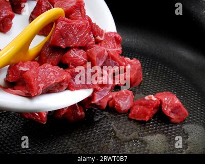 Mettere il gulasch nella padella Foto Stock