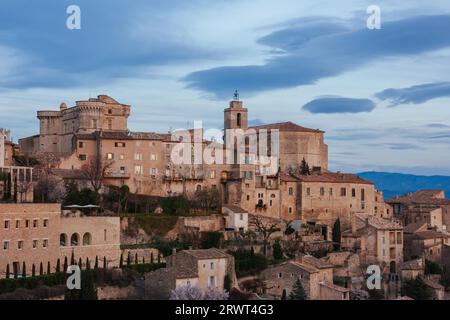 Il sole scende al crepuscolo in una giornata invernale a Gordes, Provenza, Francia Foto Stock