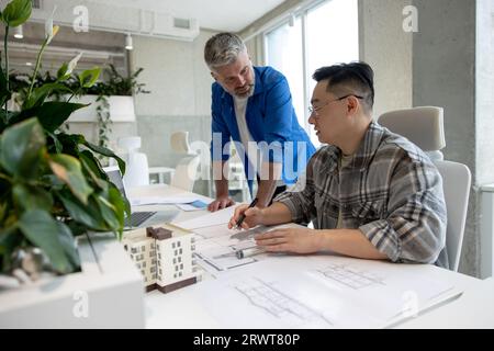 Uomini che lavorano con una stampante 3D e un progetto per la progettazione di parti meccaniche in officine high tech. Foto Stock