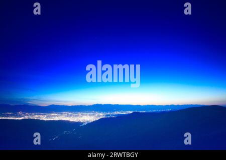 La città di Matsumoto al tramonto, la catena montuosa Hotaka e altre montagne viste da Ohgahana Foto Stock