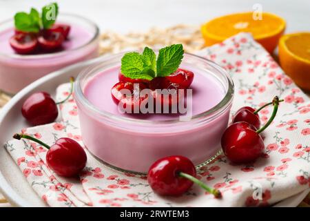 Panna cotta alla ciliegia servita in un bicchiere con frutta fresca e cioccolato grattugiato. Foto Stock