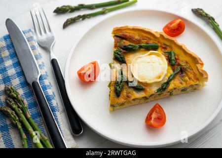 Quiche alla francese con asparagi verdi, uova e fette di formaggio di capra. Foto Stock