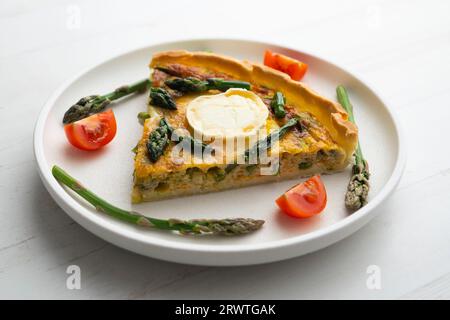 Quiche alla francese con asparagi verdi, uova e fette di formaggio di capra. Foto Stock