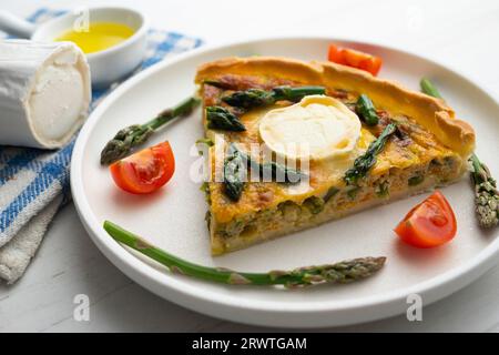 Quiche alla francese con asparagi verdi, uova e fette di formaggio di capra. Foto Stock