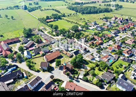 Vista aerea dal bordo di un villaggio nel nord della Germania con terreni agricoli e piccole zone di foresta nell'area circostante Foto Stock
