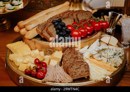 Un piatto artigianale con una varietà di salumi, pane artigianale e una selezione di formaggi. Foto Stock