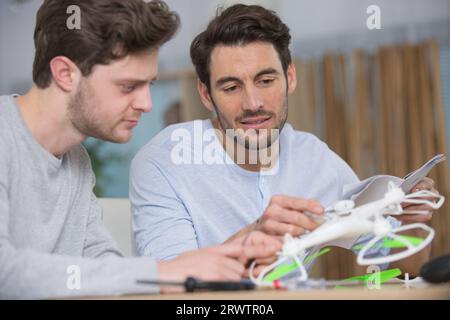 gli uomini droni in mano la riparano Foto Stock