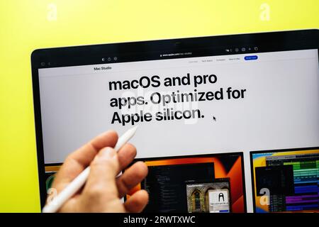 Parigi, Francia - 6 giugno 2023: Una mano maschile impiega una matita per evidenziare le caratteristiche delle nuove app MacOS e Pro, ottimizzate per Apple Silicon, mentre è in funzione un notebook Foto Stock