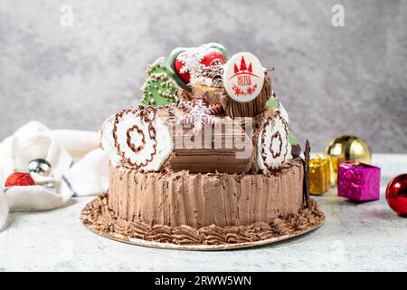 Torta per festeggiare il Natale. Il concetto di Capodanno. Torta log di design del nuovo anno con sfondo grigio. Primo piano Foto Stock