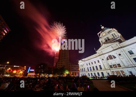 Fuochi d'artificio rossi brillanti sulla torre Lincoln del centro di Fort Wayne da una vista affollata del tribunale Foto Stock