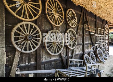 Hida village carts and a view of many wheels displayed on the outside wall Stock Photo