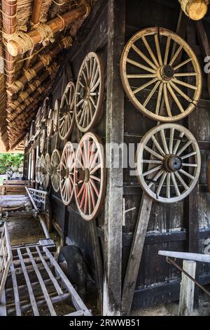 Carri del villaggio di Hida e una vista di molte ruote esposte sulla parete esterna Foto Stock