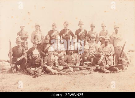 Ritratto di gruppo di uomini europei e indiani vestiti con una varietà di uniformi militari, in posa per una fotografia con le loro armi. E H Dring appare al centro della fila posteriore. La didascalia recita: Squadra indiana di Wimbledon. Foto Stock