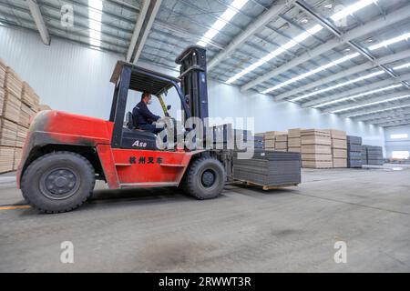 Contea di Luannan, Cina - 17 giugno 2023: I lavoratori utilizzano carrelli elevatori per trasportare nuovi materiali da costruzione in una fabbrica, nel nord della Cina Foto Stock