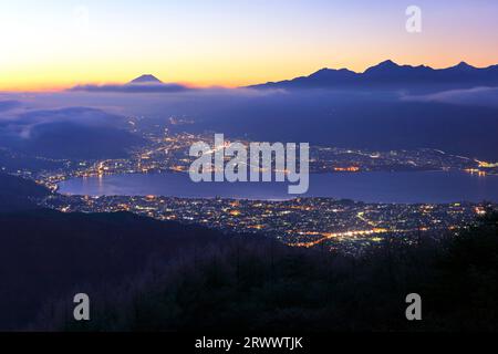 Lago Suwa e luci della città dall'altopiano di Takabotchi Foto Stock