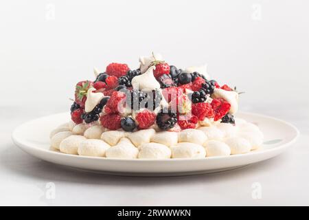 Torta di meringa Pavlova con frutti di bosco freschi e mascarpone panna montata. Ricetta del dolce tradizionale Anna Pavlova. Pasticceria fatta in casa. Foto Stock