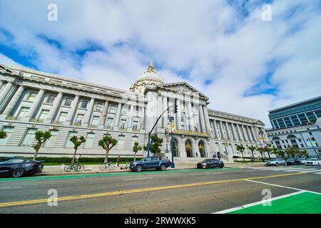 Auto e biciclette parcheggiate lungo la strada di fronte al municipio di San Francisco Foto Stock