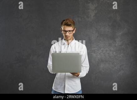 Programmatore o dipendente maschio intelligente concentrato che lavora al progetto di avvio. Foto Stock