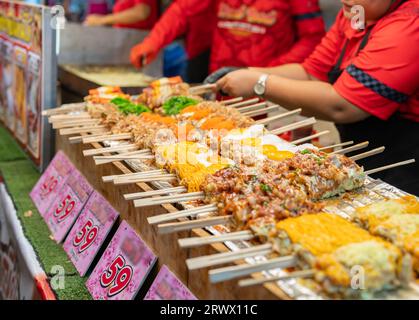 Bastoncini per pizza con condimento vario pronti per la vendita nel mercato di Street food. Foto Stock