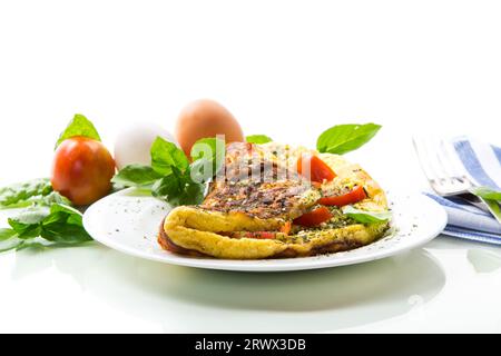 Frittata ripiena con pomodori isolati su fondo bianco. Cibo salutare per la colazione. Foto Stock