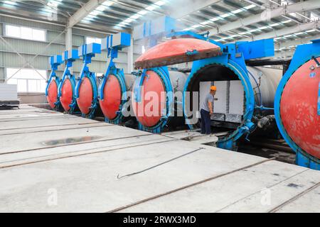 Contea di Luannan, Cina - 27 giugno 2023: I lavoratori stanno manipolando l'autoclave dei materiali da costruzione per il trasporto nella fabbrica Foto Stock