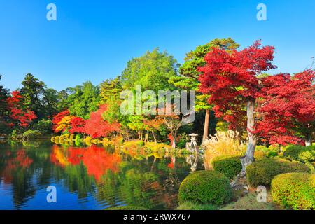 Foglie autunnali a Kanazawa Kenrokuen con lanterne Koji e laghetto di Kasumigaike Foto Stock