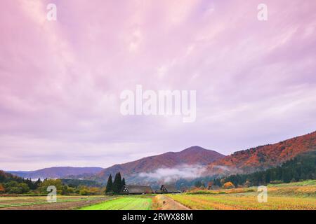 Shirakawa-go in autunno - foglie rosse e nuvole di bagliore mattutino Foto Stock