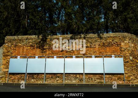 Cinque bacheche vuote montate su un muro di pietra davanti agli alberi. Segni di elezioni Campaings. Francia Foto Stock