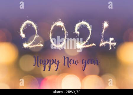 Felice anno nuovo 2024 scritto con scintille su sfondo sfocato con luci bokeh, biglietto d'auguri natalizio Foto Stock