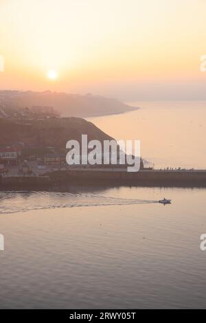 Tramonto su Whitby dal cimitero della chiesa parrocchiale di St Mary's, nel North Yorkshire, Regno Unito Foto Stock