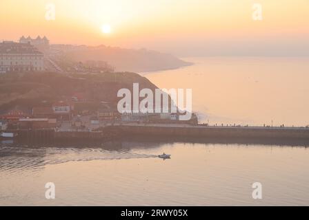 Tramonto su Whitby dal cimitero della chiesa parrocchiale di St Mary's, nel North Yorkshire, Regno Unito Foto Stock