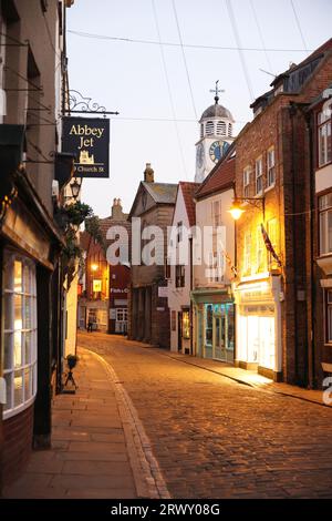 Graziosi negozi indipendenti, caffetterie e bar in Church Street nel centro storico di Whitby nel North Yorkshire, Regno Unito Foto Stock