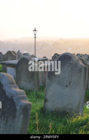 Tramonto sul cimitero della storica St Mary's Church, sulla scogliera orientale ventilata dall'abbazia di Whitby nel North Yorkshire, Regno Unito Foto Stock