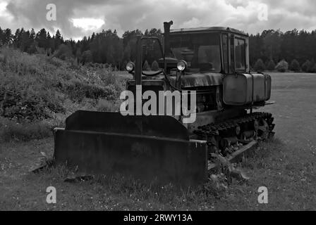 Rusty vintage scavatrice abbandonata in una fattoria estone. Foto Stock