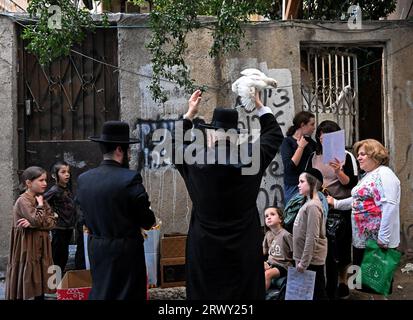 Gerusalemme, Israele. 21 settembre 2023. Un ebreo ultra-ortodosso alza un pollo sulla sua testa durante l'antico rituale Kapparot a Mea Shearim a Gerusalemme, giovedì 21 settembre 2023. Il Kapparot è preformato prima dello Yom Kippur, il giorno dell'Espiazione, il giorno più sacro del calendario ebraico, e trasferisce simbolicamente i peccati dell'anno passato al pollo. Foto di Debbie Hill/ Credit: UPI/Alamy Live News Foto Stock