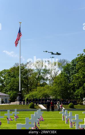 B-17 Flying Fortress Sally B e gli aerei da caccia effettuata una flypast commemorative oltre il Cambridge Cimitero e memoriale americano a bandiera statunitense, attraversa Foto Stock