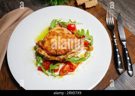 Lasagne con salsiccia chorizo piccante, funghi selvatici in salsa panna, guarnita con insalata di rucola e pomodori ciliegini Foto Stock