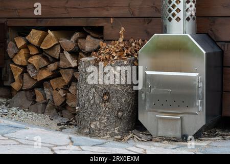 Una pila di tronchi appena tagliati impilati ordinatamente all'esterno di un edificio vicino a un caminetto Foto Stock