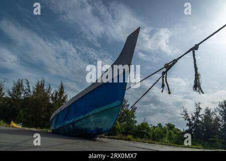 Barche da pesca in legno parcheggiate sulla spiaggia durante il monsone, Kerala. Foto Stock