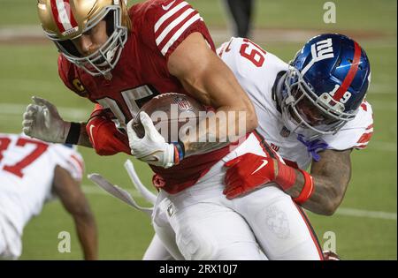 Il tight end dei San Francisco 49ers George Kittle (85) viene trascinato giù dalla safety dei New York Giants Isaiah Simmons (19) nel quarto quarto quarto al Levi's Stadium di Santa Clara, California, giovedì 21 settembre 2023. I 49ers sconfissero i Giants 30-12. Foto di Terry Schmitt/UPI Foto Stock