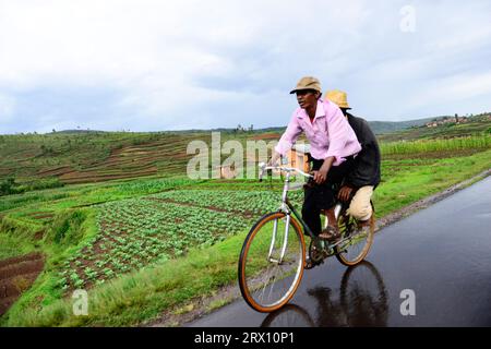 Abitanti malgasci che camminano lungo la strada nel Madagascar centrale. Foto Stock