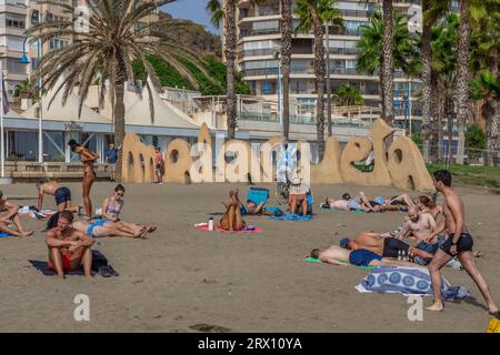 Spiaggia di Malagueta a Malaga alla luce del sole autunnale. Cielo blu sopra. Gente che prende il sole sotto il cielo blu della costa del sol. Foto Stock