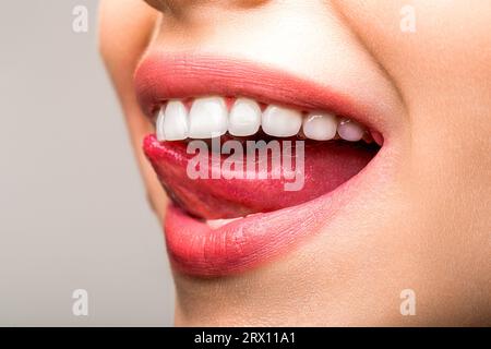 Foto ravvicinata del sorriso toothy della donna. Denti sani perfetti sorridere donna. Concetto di salute dentale. Procedura di sbiancamento dei denti. Cure dentistiche. Lingua femminile Foto Stock