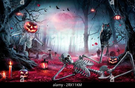 Halloween - scheletri nella foresta di Spooky a Moonlight - Jack o' Lanterns nel Cimitero a Twilight Foto Stock