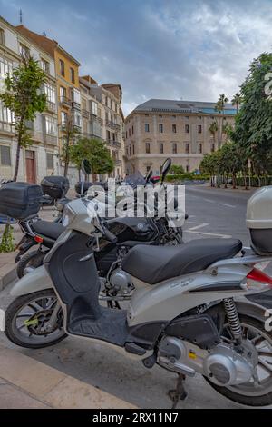 Splendida vista del parcheggio cittadino per gli scooter sul Paseo del Parque a Malaga. Foto ravvicinate su molti scooter assortiti parcheggiati. Mattina presto. Foto Stock