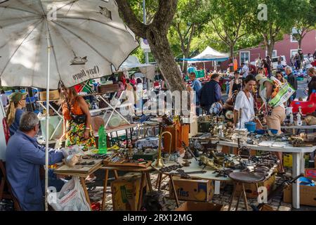 L'affollato mercato di strada di Feira da Ladra, aperto due volte alla settimana, nel quartiere Alfama di Lisbona, specializzato in antiquariato, oggetti da collezione e bric-a-brac (Portogallo) Foto Stock