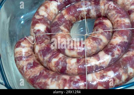 salsiccia cruda. Salsiccia di maiale fatta in casa. Salsiccia fatta in casa sul piatto. primo piano Foto Stock