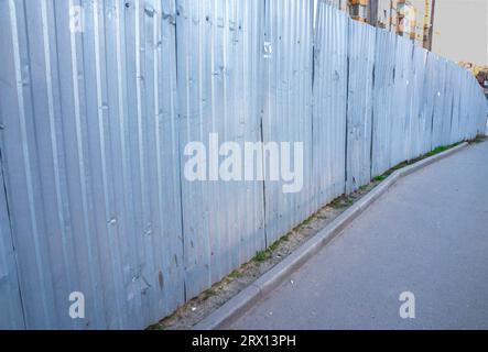 Una recinzione metallica lungo il marciapiede. Recinzioni del cantiere. recinzione, recinzione, protezione Foto Stock